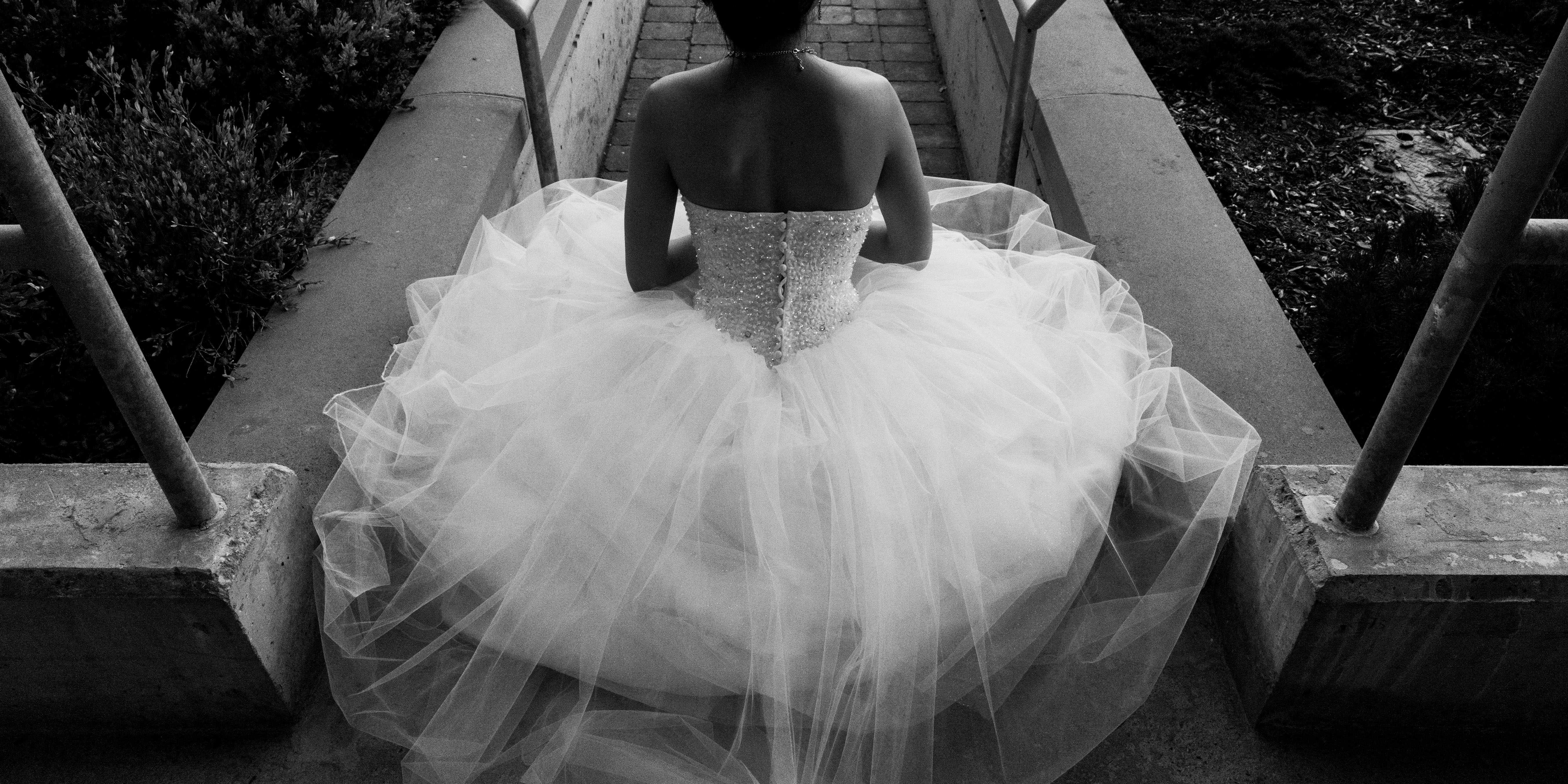 A Korean bride sits on a step in her strapless princess ball gown during her summer Toronto wedding